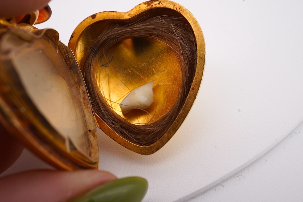A modern embossed 9ct gold heart shaped locket, 21mm, on a similar 9ct gold rope twist chain, 46cm, together with one other yellow metal heart shaped locket, on a yellow metal chain, gross weight 14.5 grams. Condition -